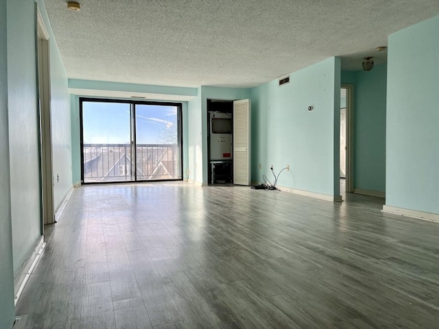 unfurnished living room featuring hardwood / wood-style floors and a textured ceiling