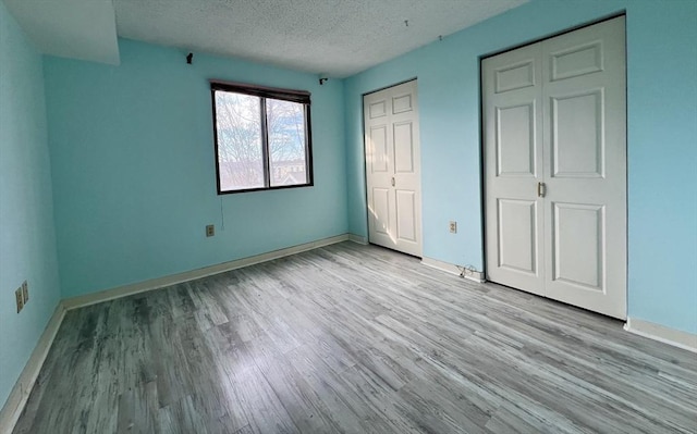 unfurnished bedroom with a textured ceiling and light hardwood / wood-style flooring