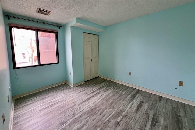 unfurnished bedroom featuring light hardwood / wood-style flooring and a textured ceiling