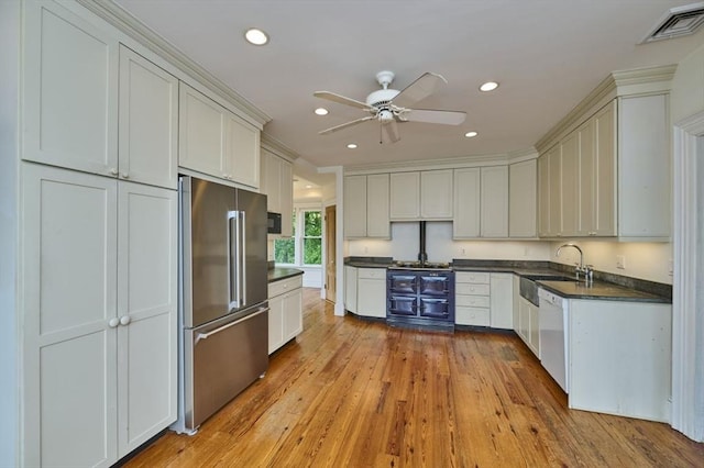kitchen featuring high end fridge, dark countertops, dishwasher, hardwood / wood-style floors, and a ceiling fan