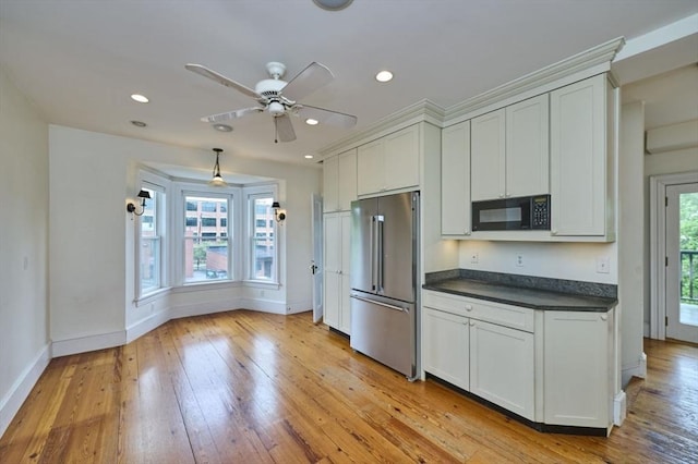 kitchen featuring high quality fridge, black microwave, dark countertops, baseboards, and recessed lighting