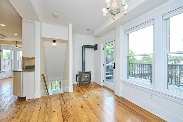unfurnished living room featuring light wood-style flooring, healthy amount of natural light, a chandelier, and recessed lighting