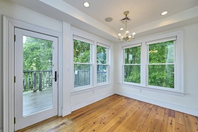 unfurnished sunroom featuring a chandelier and healthy amount of natural light