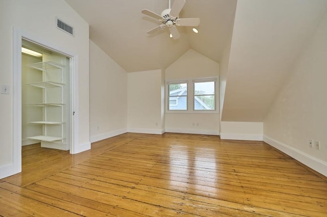 additional living space with light wood-type flooring, lofted ceiling, built in shelves, ceiling fan, and baseboards