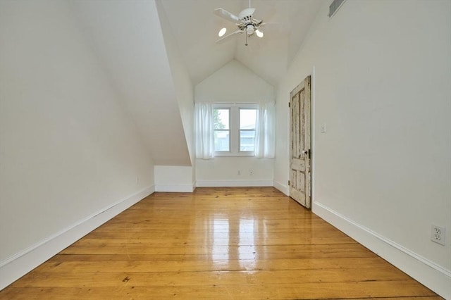 additional living space with vaulted ceiling, ceiling fan, light wood finished floors, and baseboards