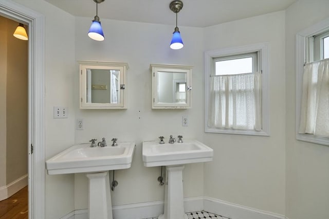 bathroom featuring baseboards and a sink