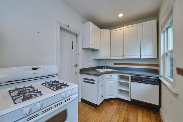 kitchen with white appliances, a sink, white cabinets, and recessed lighting