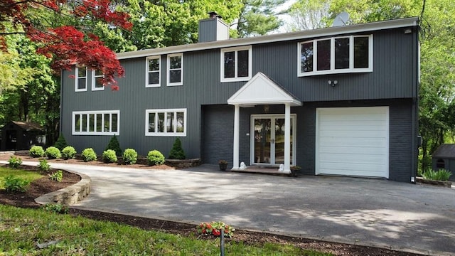 2218 Turnpike St, North Andover, MA 01845 - colonial inspired home with french doors, driveway, a chimney, an attached garage, and brick siding