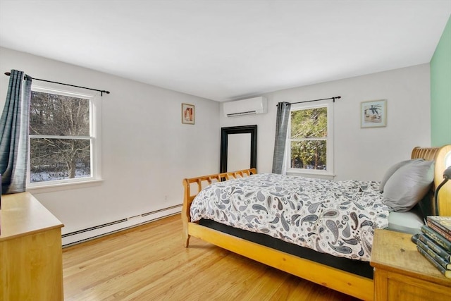 bedroom with a baseboard heating unit, hardwood / wood-style flooring, and a wall unit AC