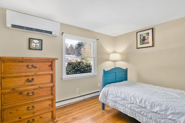 bedroom with an AC wall unit, light wood-type flooring, and a baseboard heating unit