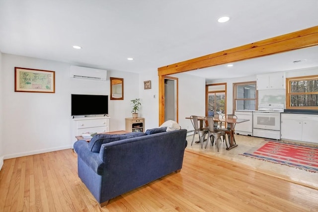 living room featuring beamed ceiling, a wall mounted AC, and light wood-type flooring