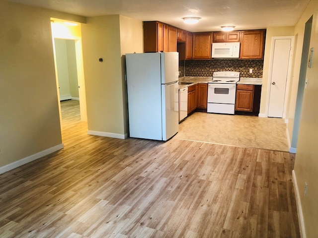 kitchen featuring white appliances, light hardwood / wood-style floors, and decorative backsplash