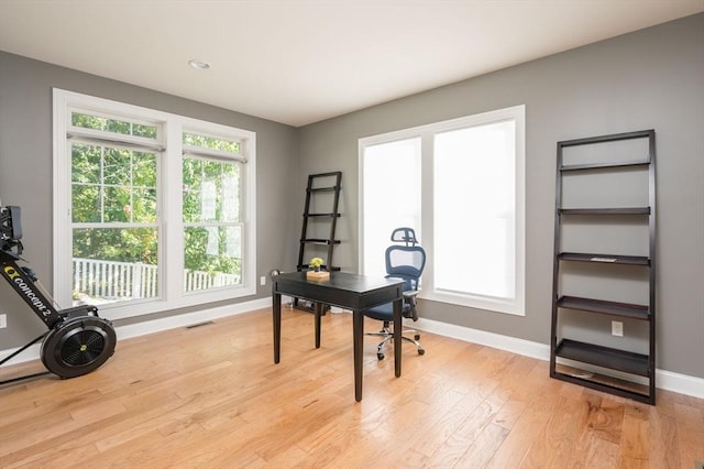 home office with plenty of natural light, baseboards, light wood-type flooring, and visible vents