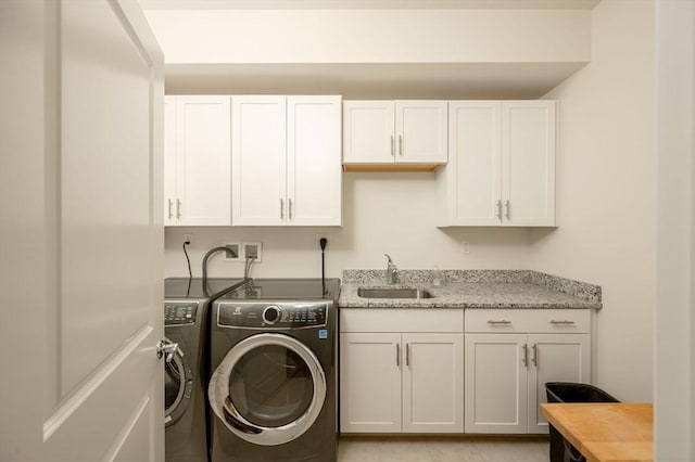 laundry area featuring cabinet space, independent washer and dryer, and a sink