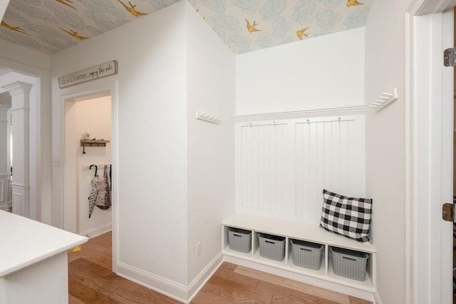 mudroom with baseboards, wood finished floors, and ornate columns