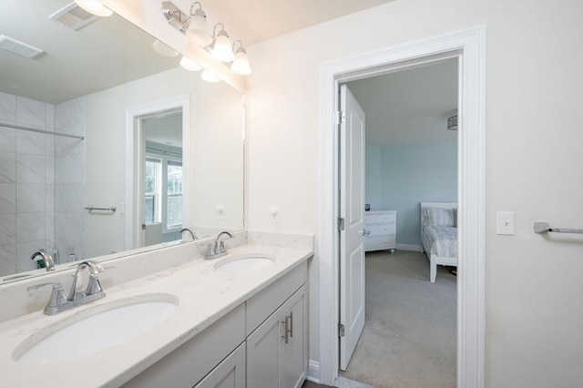 ensuite bathroom with double vanity, visible vents, and a sink