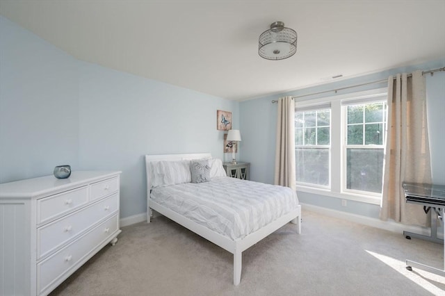 bedroom with baseboards and light colored carpet