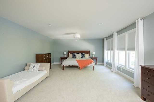 bedroom featuring light colored carpet and baseboards