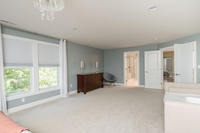 bedroom with visible vents, light carpet, ensuite bath, an inviting chandelier, and baseboards