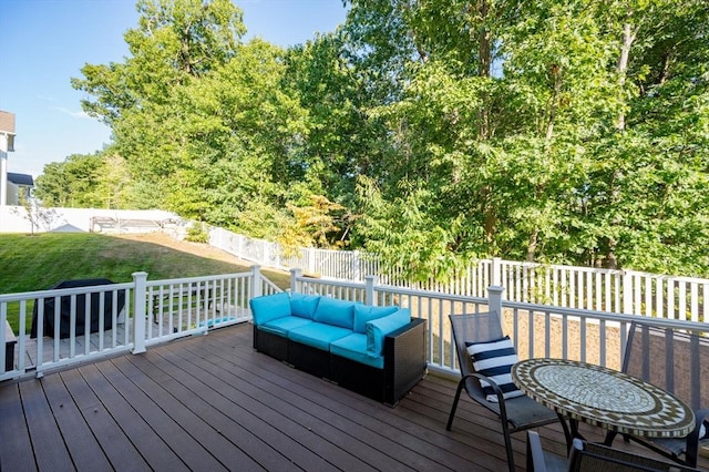 wooden deck with a yard, an outdoor hangout area, and a fenced backyard