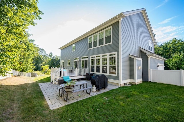 back of house featuring a deck, a patio, a yard, and fence