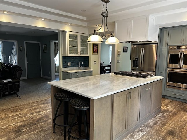 16 Pinehurst Ave, Dracut, MA 01826 - kitchen featuring appliances with stainless steel finishes, glass insert cabinets, tasteful backsplash, a center island, and dark wood-style flooring