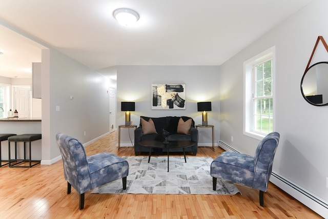 living room with a baseboard radiator and light hardwood / wood-style flooring