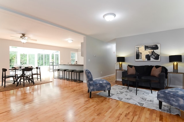 living room featuring a wealth of natural light, ceiling fan, and light hardwood / wood-style floors