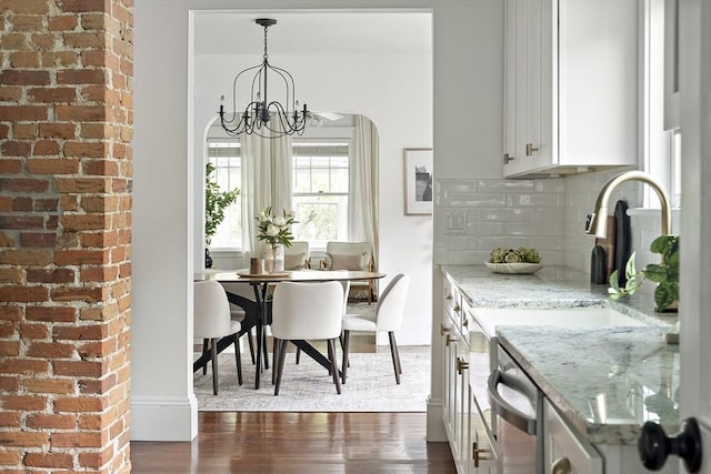 232 Powder House Blvd Unit 232, Somerville, MA 02144 - kitchen with dark wood-style floors, decorative backsplash, a chandelier, white cabinets, and light stone counters