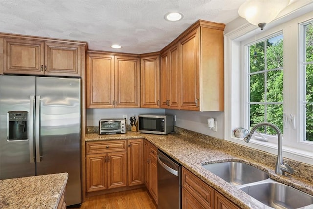 3 Trophy Ave, Townsend, MA 01469 - kitchen with appliances with stainless steel finishes, a sink, brown cabinetry, light stone countertops, and recessed lighting