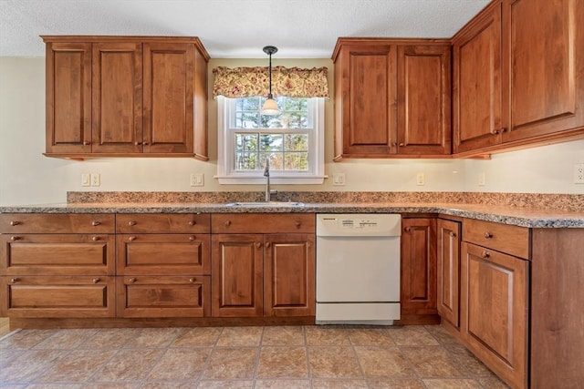 kitchen featuring brown cabinets, white dishwasher, a textured ceiling, and a sink