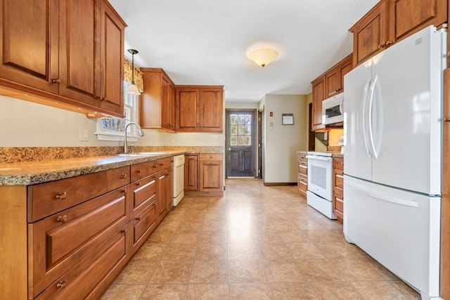 kitchen featuring a sink, brown cabinets, and white appliances