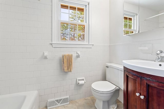 bathroom featuring visible vents, vanity, toilet, and tile walls