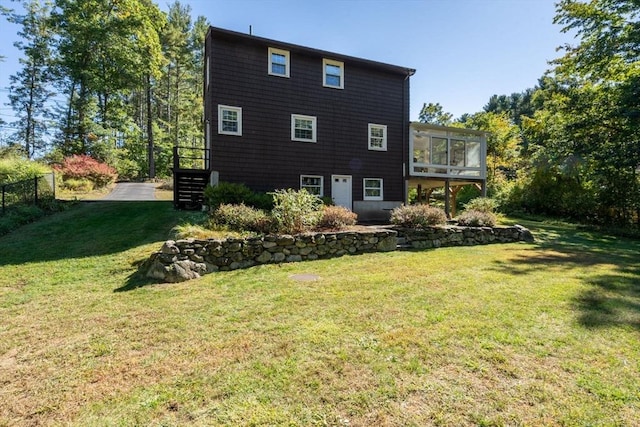 rear view of property featuring a sunroom, fence, and a yard
