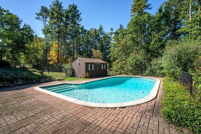 view of swimming pool featuring a storage shed, a patio area, a fenced in pool, an outdoor structure, and a fenced backyard