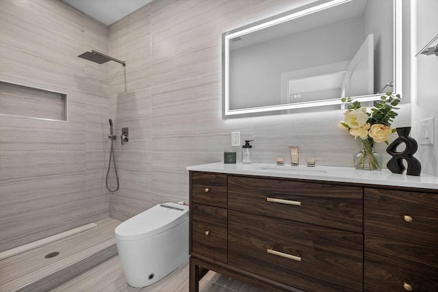 bathroom with tile walls, tiled shower, vanity, and toilet