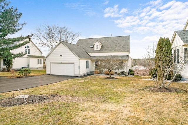 view of front facade featuring aphalt driveway, an attached garage, and a front lawn