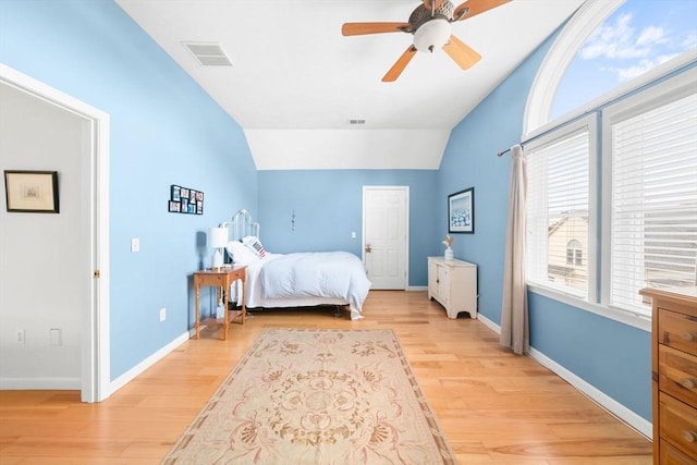 bedroom with lofted ceiling, light wood-style flooring, visible vents, and baseboards