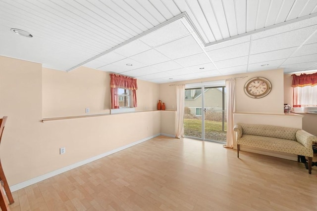 unfurnished room featuring a healthy amount of sunlight, baseboards, and wood finished floors