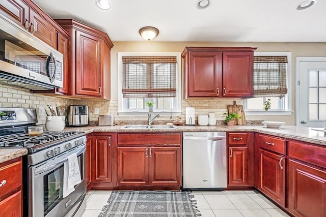 40 Winchester Ln Unit 10, Fall River, MA 02721 - kitchen with appliances with stainless steel finishes, a sink, dark brown cabinets, light tile patterned floors, and tasteful backsplash