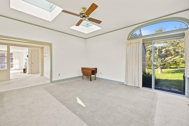 carpeted spare room with a skylight and baseboards