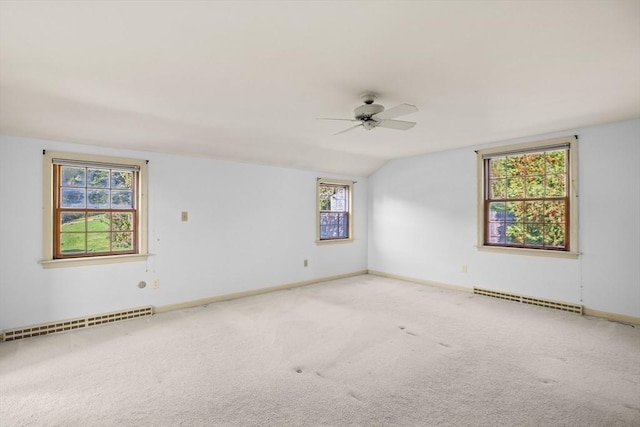 empty room with a baseboard radiator, baseboards, lofted ceiling, and carpet