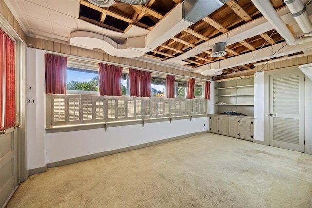 spare room featuring light colored carpet and baseboards