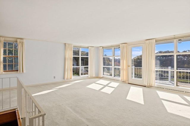 carpeted empty room featuring baseboards