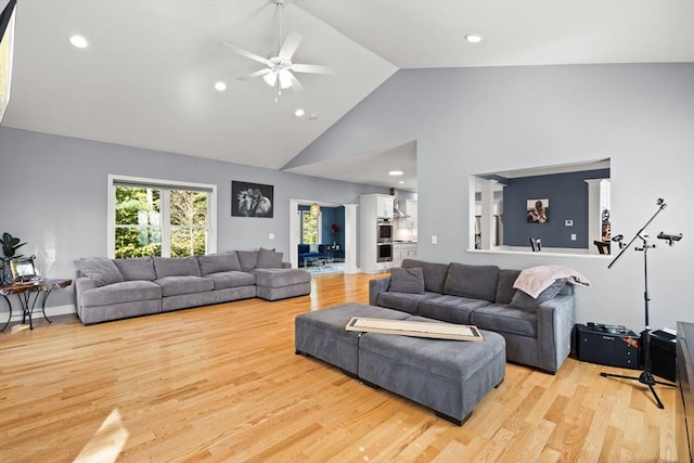 living room featuring light wood-style flooring, high vaulted ceiling, ceiling fan, and recessed lighting