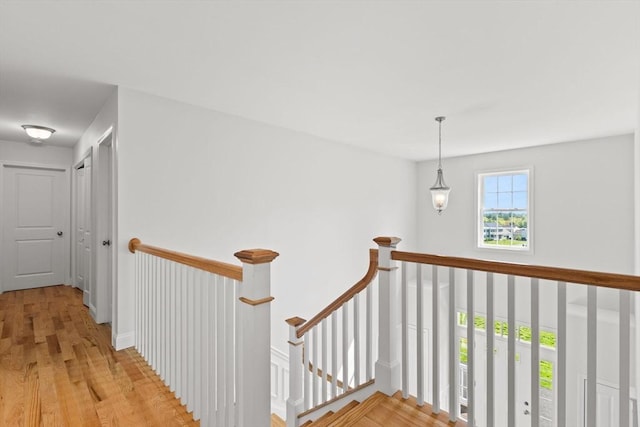 hallway featuring an upstairs landing and light wood finished floors