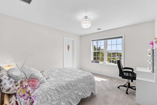 carpeted bedroom featuring baseboards and a chandelier