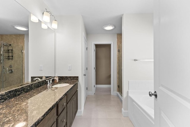full bathroom with tile patterned floors, a shower stall, vanity, a garden tub, and baseboards