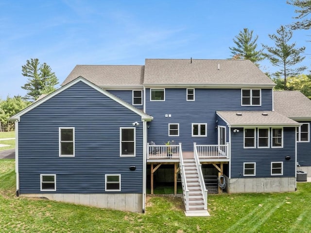 back of property featuring a wooden deck, stairs, cooling unit, a lawn, and a shingled roof