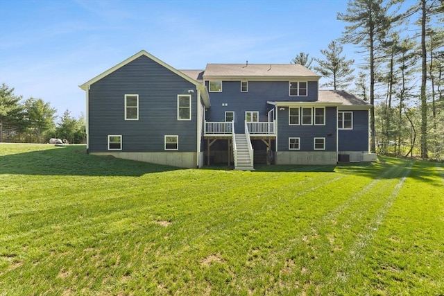 back of property with stairway, a deck, and a lawn